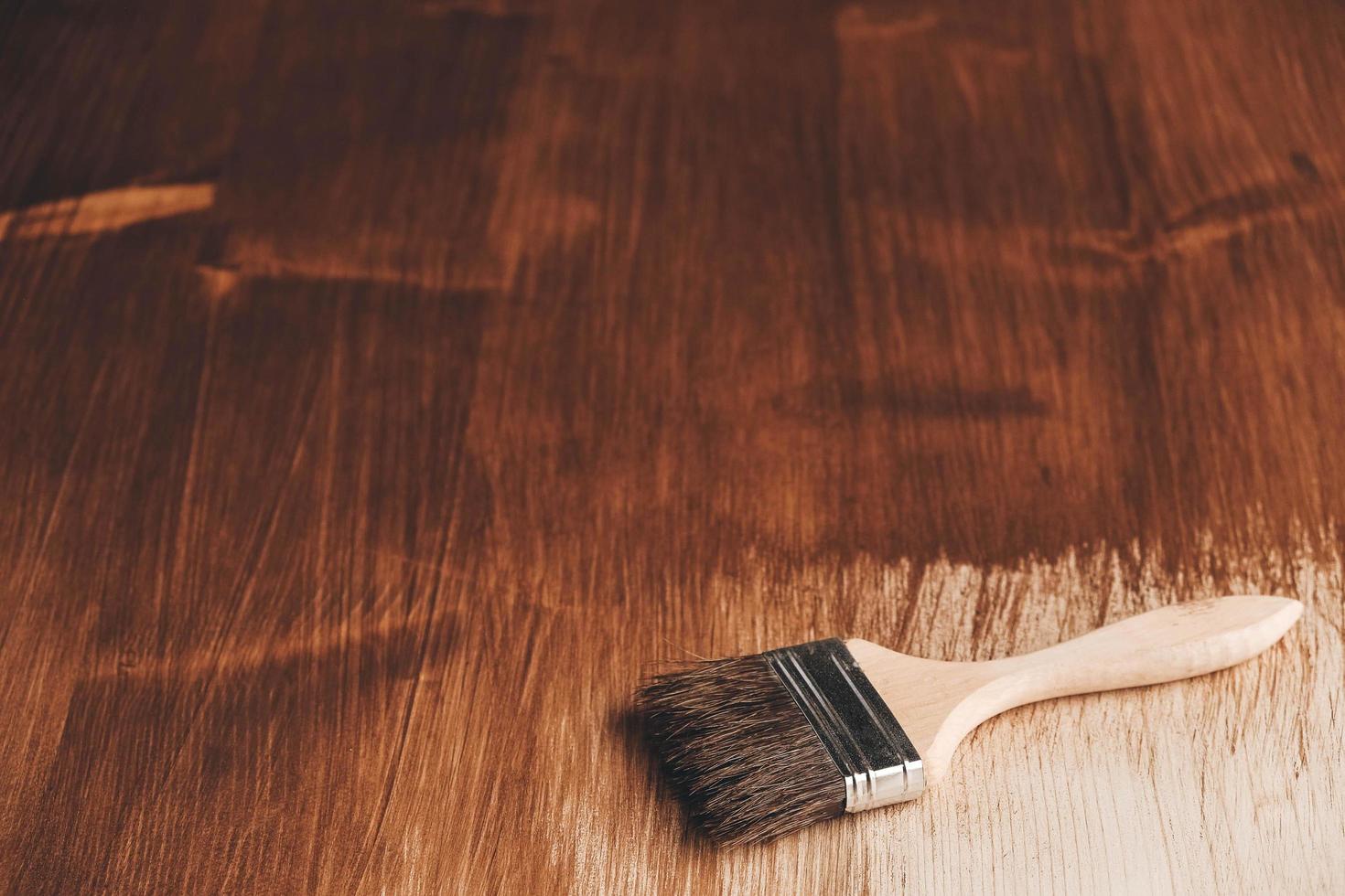 spazzola con manico in legno e setole naturali su sfondo di assi di legno dipinte di marrone foto