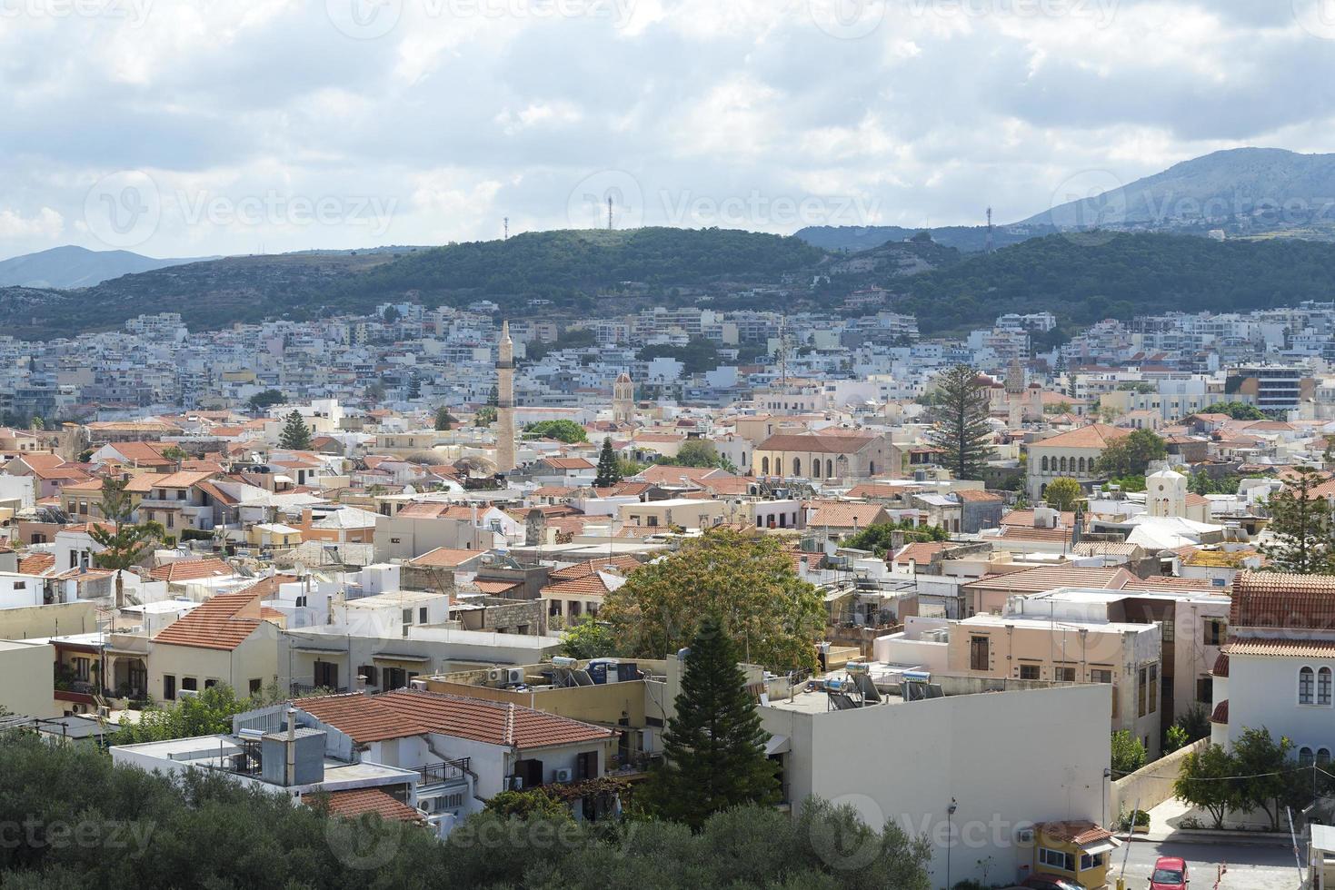 vista del resort architettura greca rethymno città-porto, costruita dai veneziani, dall'altezza del castello fortezza - fortezza sulla collina paleokastro. tetti di tegole rosse e montagne sullo sfondo. Creta. foto