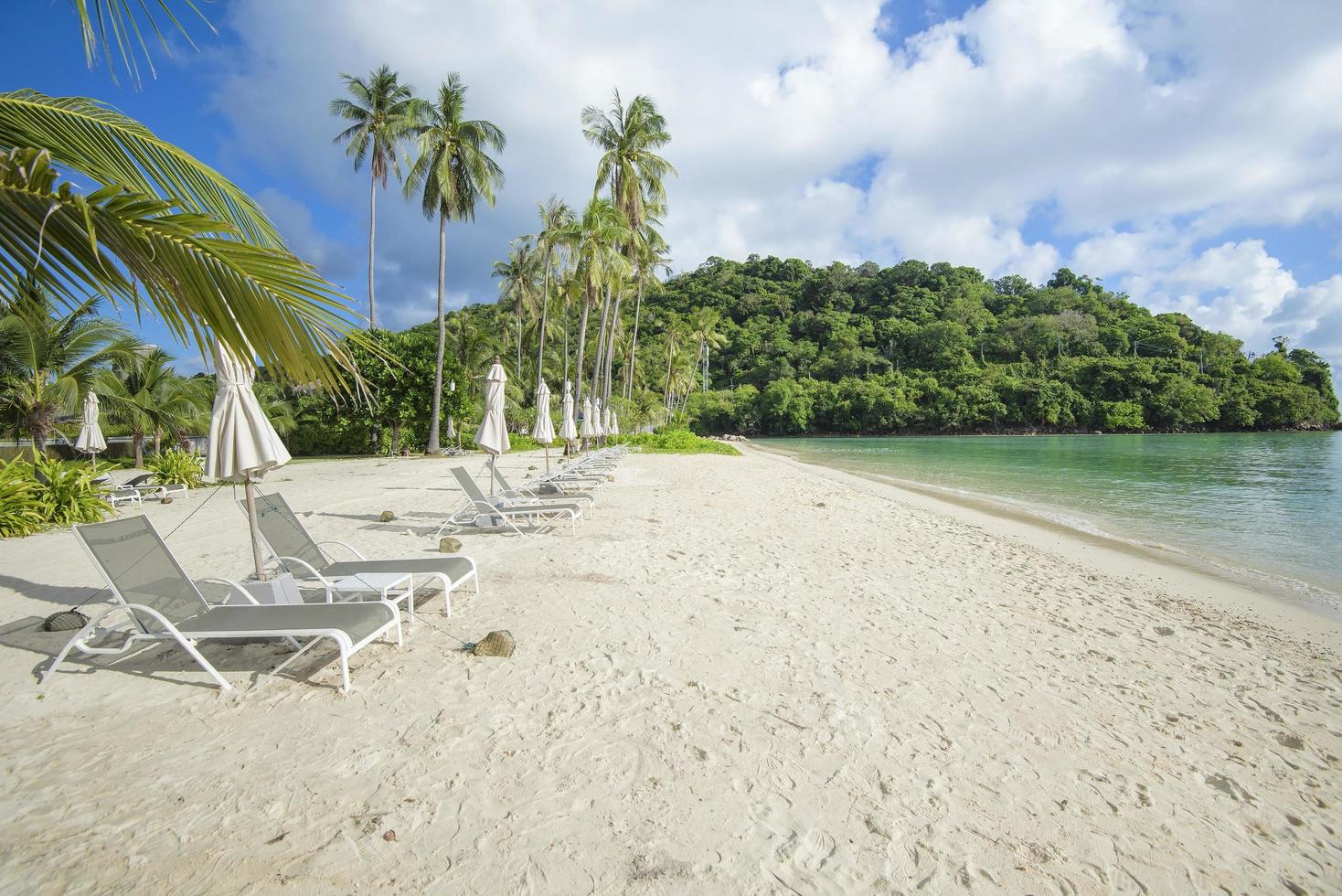 bella vista paesaggio di sedie a sdraio sulla spiaggia tropicale, il mare color smeraldo e la sabbia bianca contro il cielo blu, maya bay nell'isola di phi phi, tailandia foto