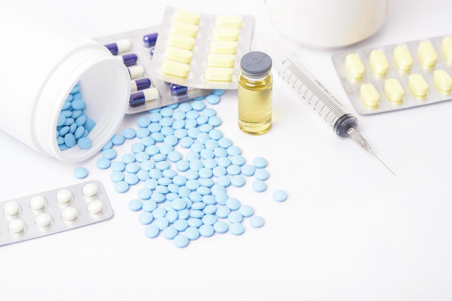 mucchi di pillole con vaccino su sfondo bianco foto
