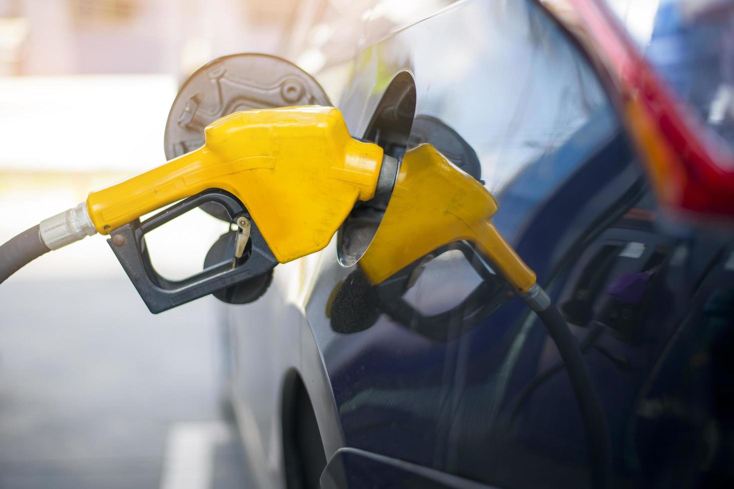 il primo piano dell'auto sta riempiendo il carburante dell'olio nella stazione di servizio foto