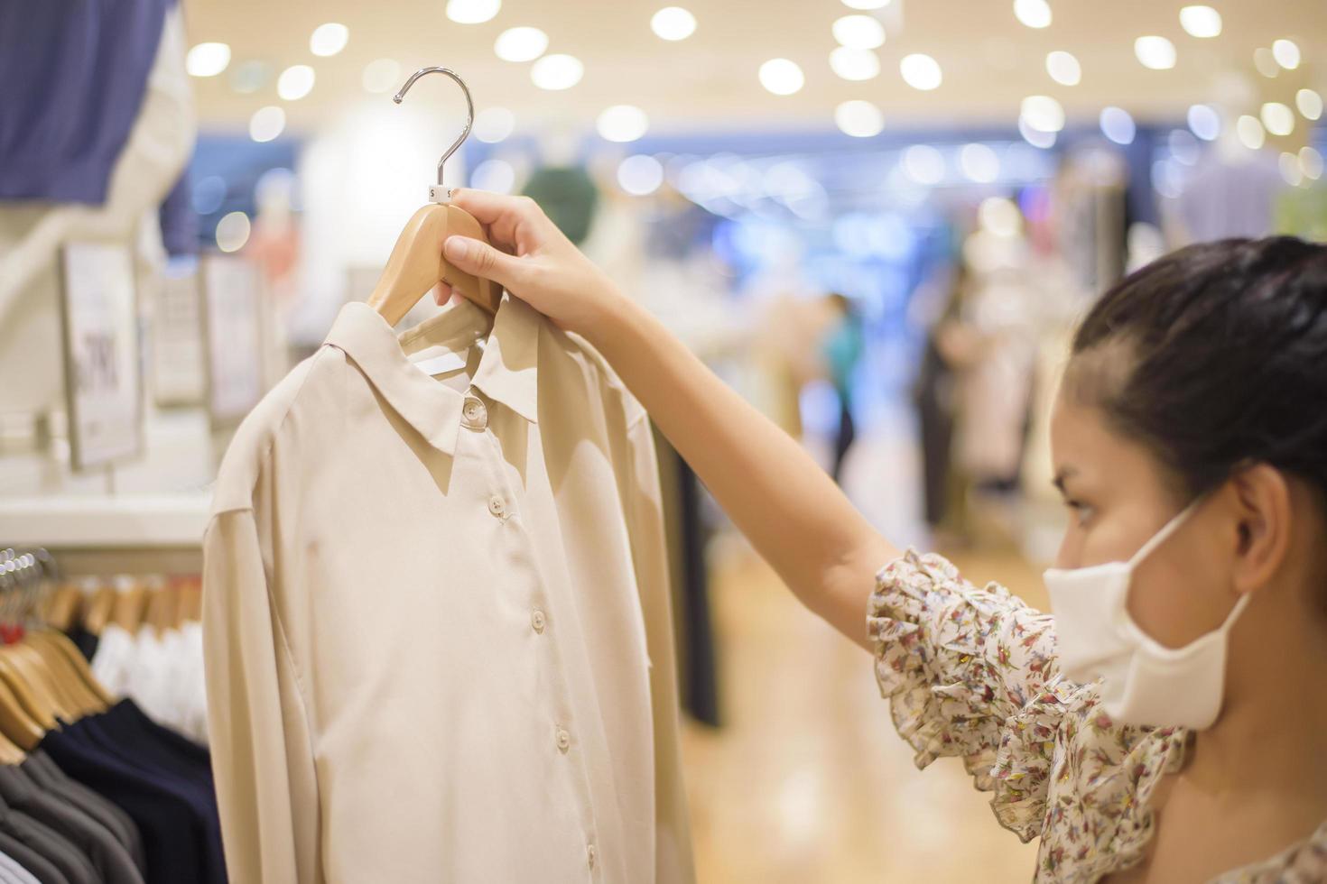 la donna con la maschera per il viso sta facendo la spesa nel centro commerciale foto