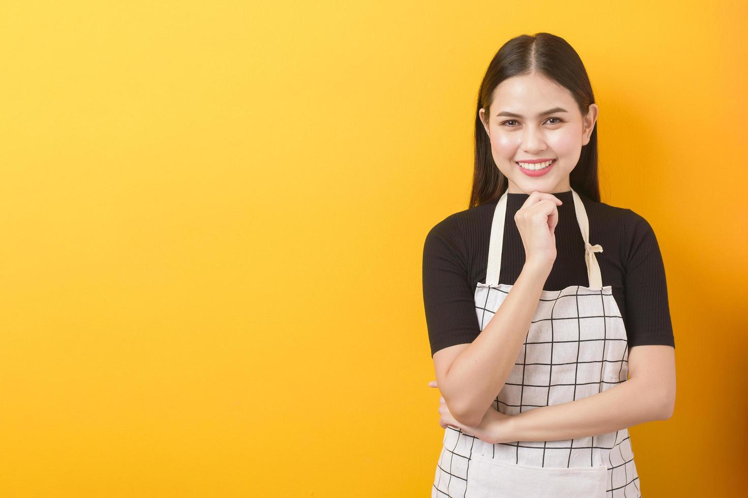 ritratto femminile felice del cuoco su fondo giallo foto