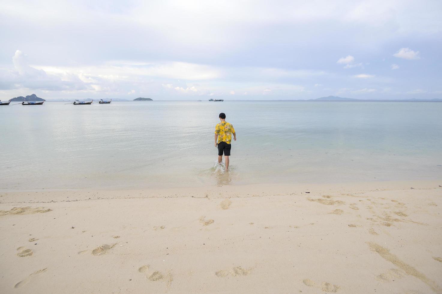 uomo felice che si diverte e si rilassa sul concetto di spiaggia, estate e vacanze foto