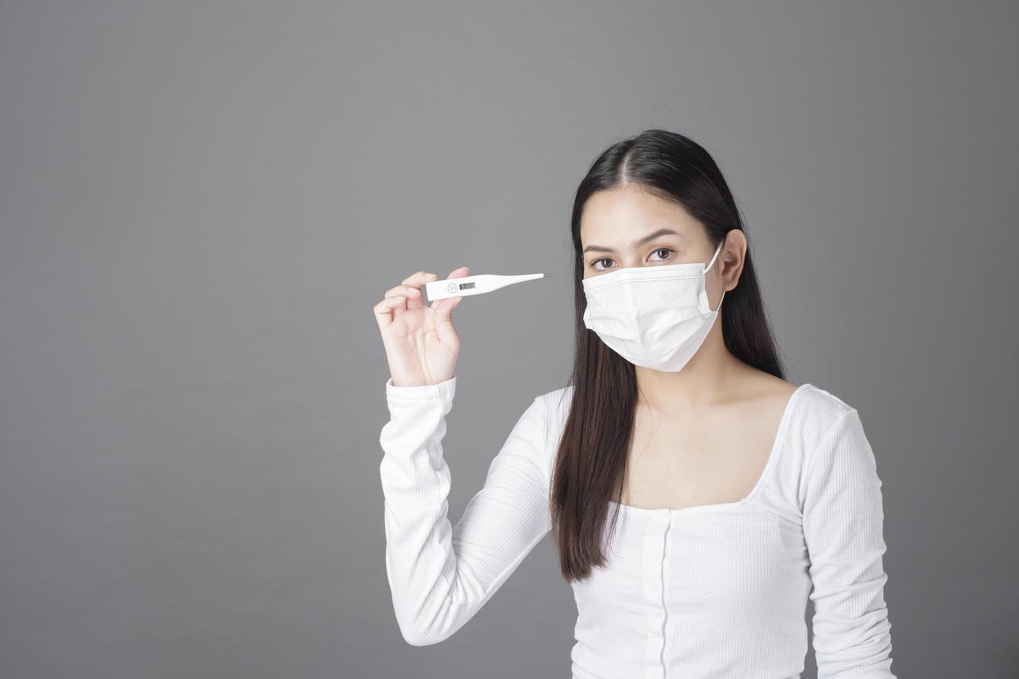 ritratto di donna con maschera chirurgica in studio, concetto di assistenza sanitaria foto