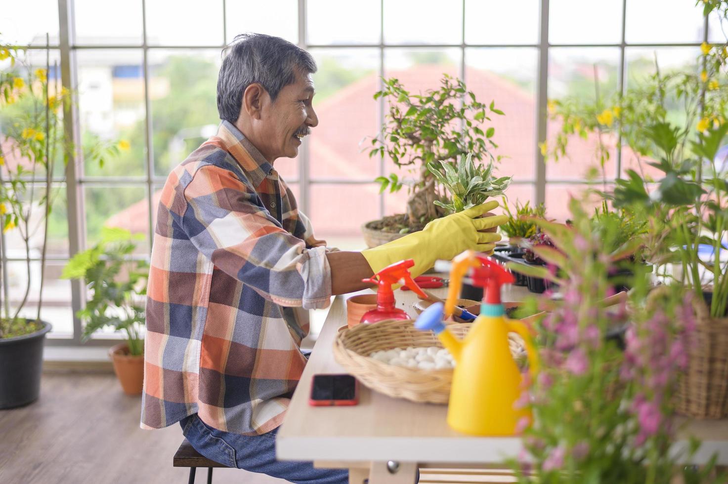 l'uomo pensionato asiatico senior felice si sta rilassando e si sta godendo l'attività di svago in giardino a casa. foto