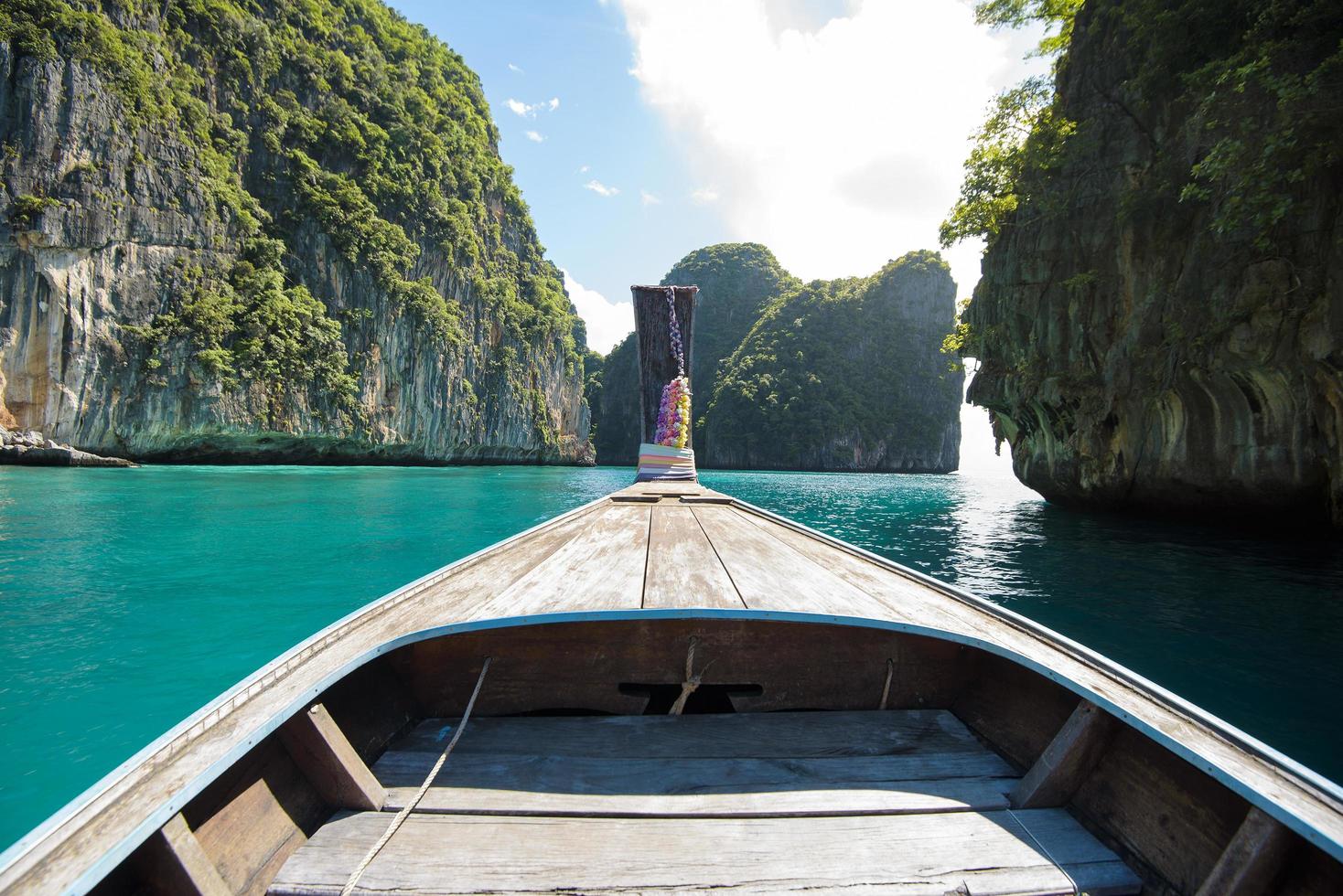 vista della tradizionale barca a coda lunga tailandese sul mare limpido e sul cielo nella giornata di sole, isole phi phi, tailandia foto