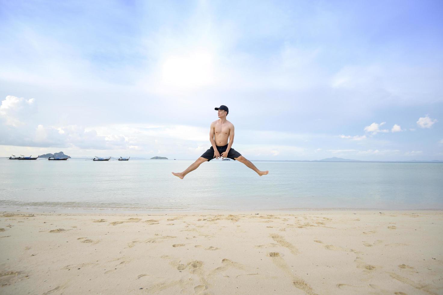 uomo felice che si diverte e si rilassa sul concetto di spiaggia, estate e vacanze foto