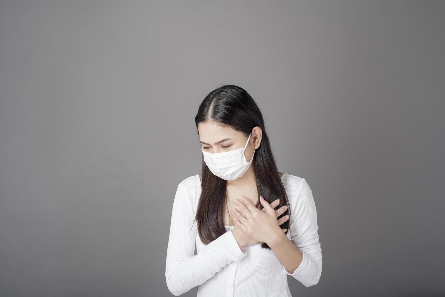 ritratto di donna con maschera chirurgica in studio, concetto di assistenza sanitaria foto