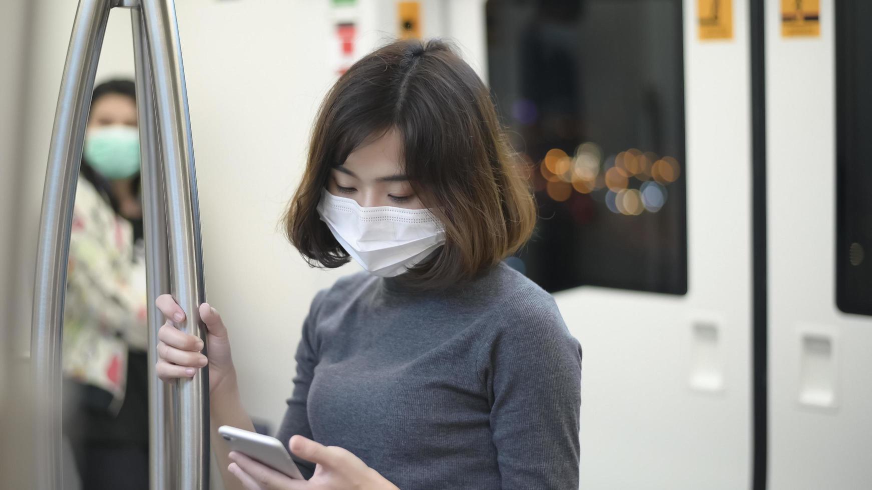 la giovane donna indossa una maschera protettiva in metropolitana, protezione covid-19, viaggi di sicurezza, nuova normalità, distanziamento sociale, trasporti di sicurezza, viaggi in condizioni di pandemia. foto