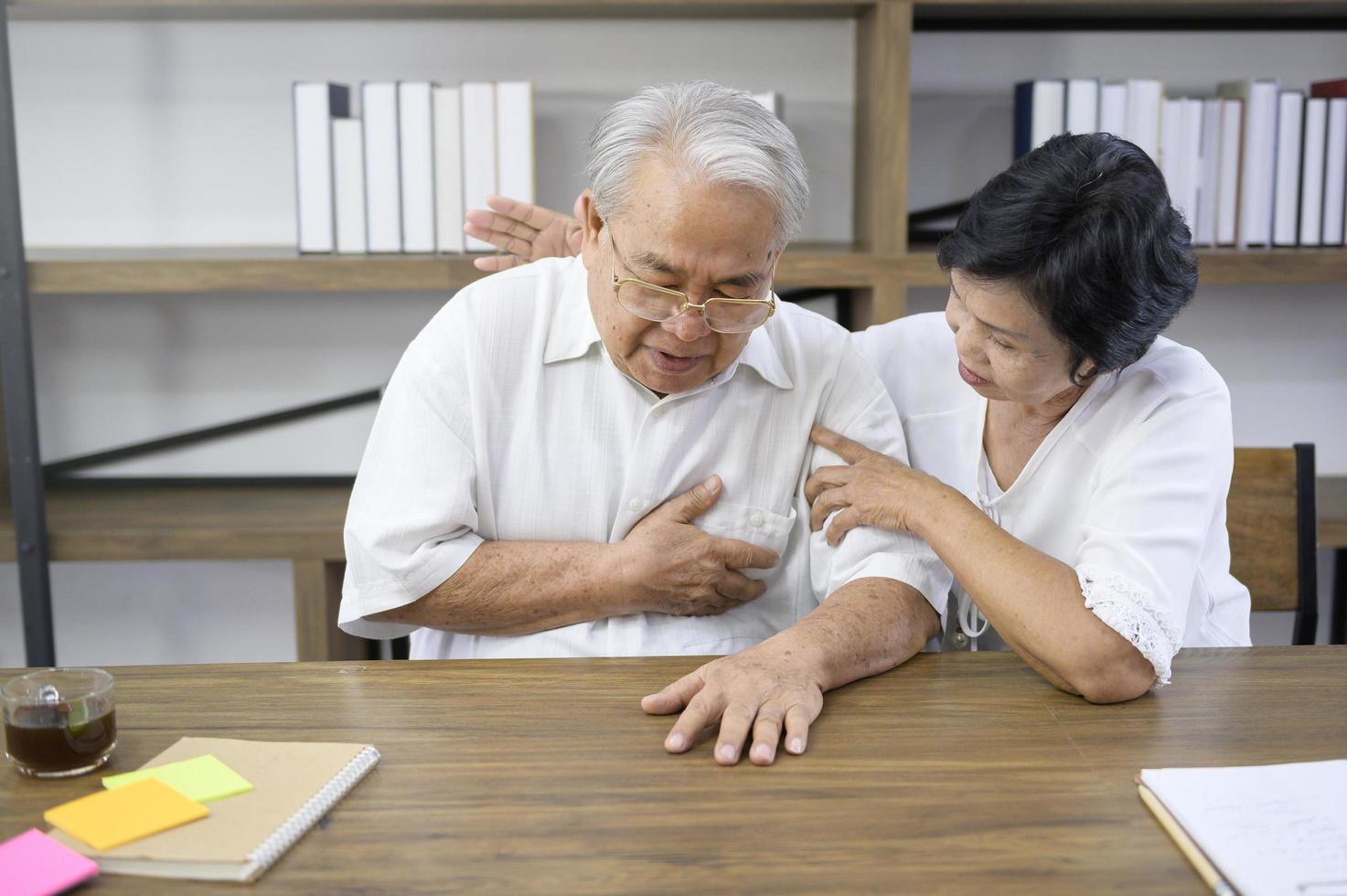 uomo asiatico anziano che ha infarto e dolore toracico a casa, concetto di salute. foto