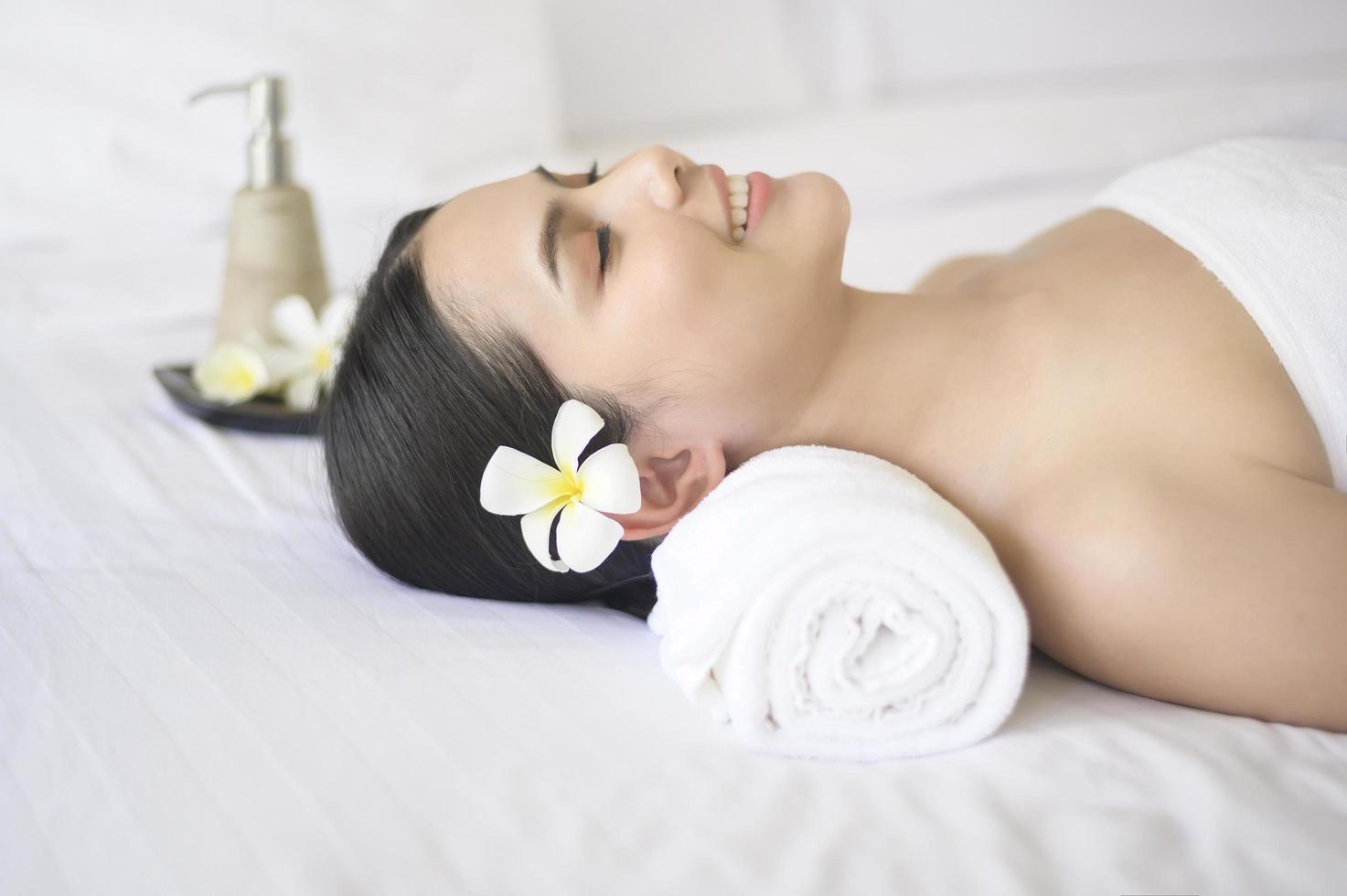una bella donna si sta rilassando e si sta facendo massaggi nel concetto di spa resort, massaggi e trattamenti di bellezza. foto