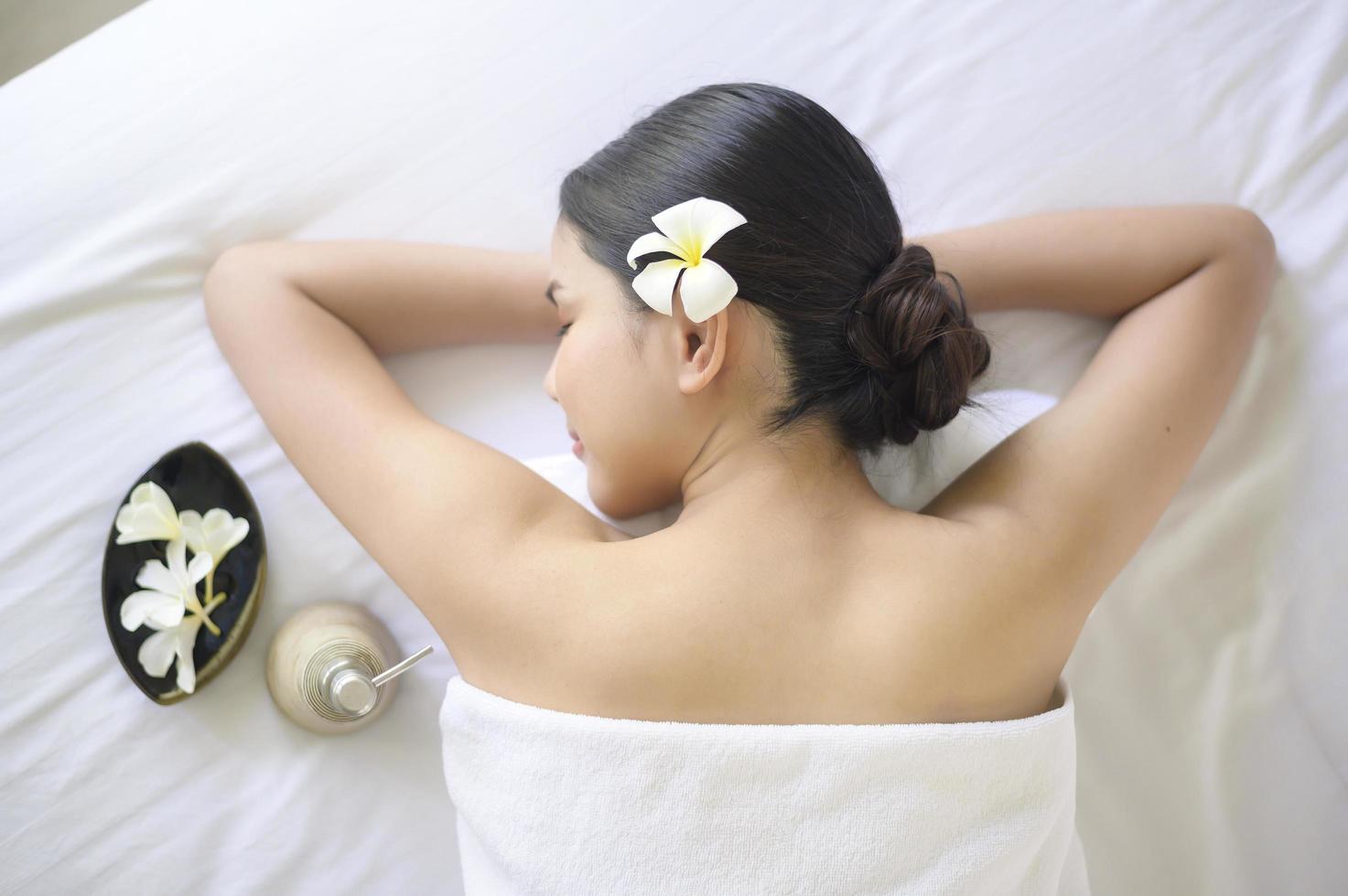 una bella donna si sta rilassando e si sta facendo massaggi nel concetto di spa resort, massaggi e trattamenti di bellezza. foto