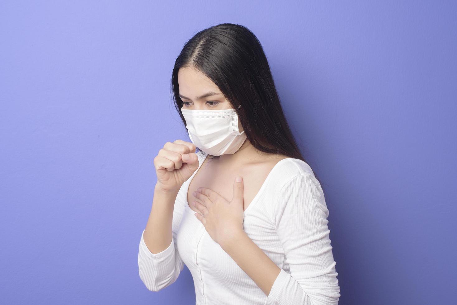 ritratto di giovane donna indossa una maschera facciale su sfondo viola foto