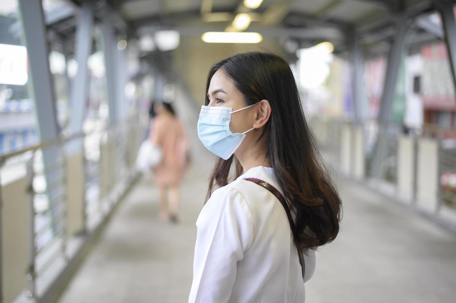 una giovane donna indossa una maschera per il viso nella città di strada. foto