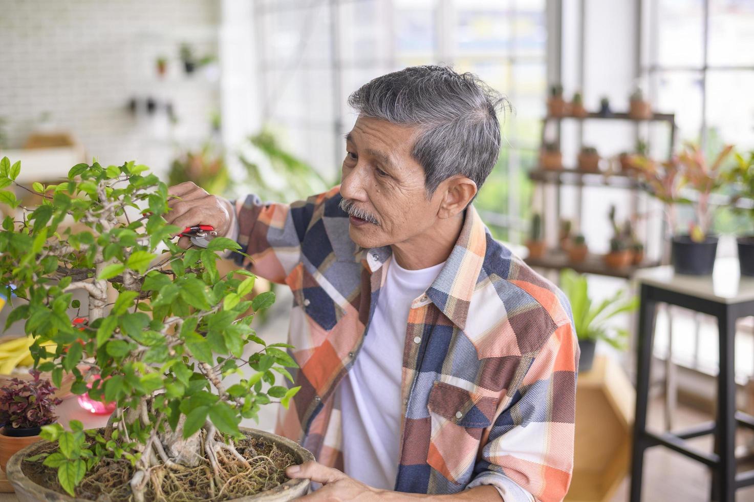 l'uomo pensionato asiatico anziano felice si sta rilassando e si sta godendo l'attività di svago in giardino a casa. foto