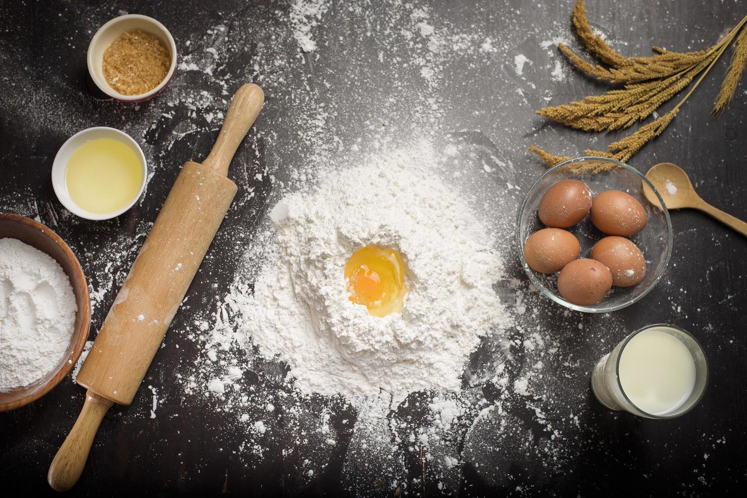 vista dall'alto della preparazione di prodotti da forno degli ingredienti su un tavolo di legno nero foto