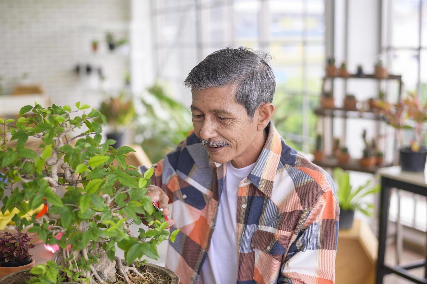 l'uomo pensionato asiatico senior felice si sta rilassando e si sta godendo l'attività di svago in giardino a casa. foto