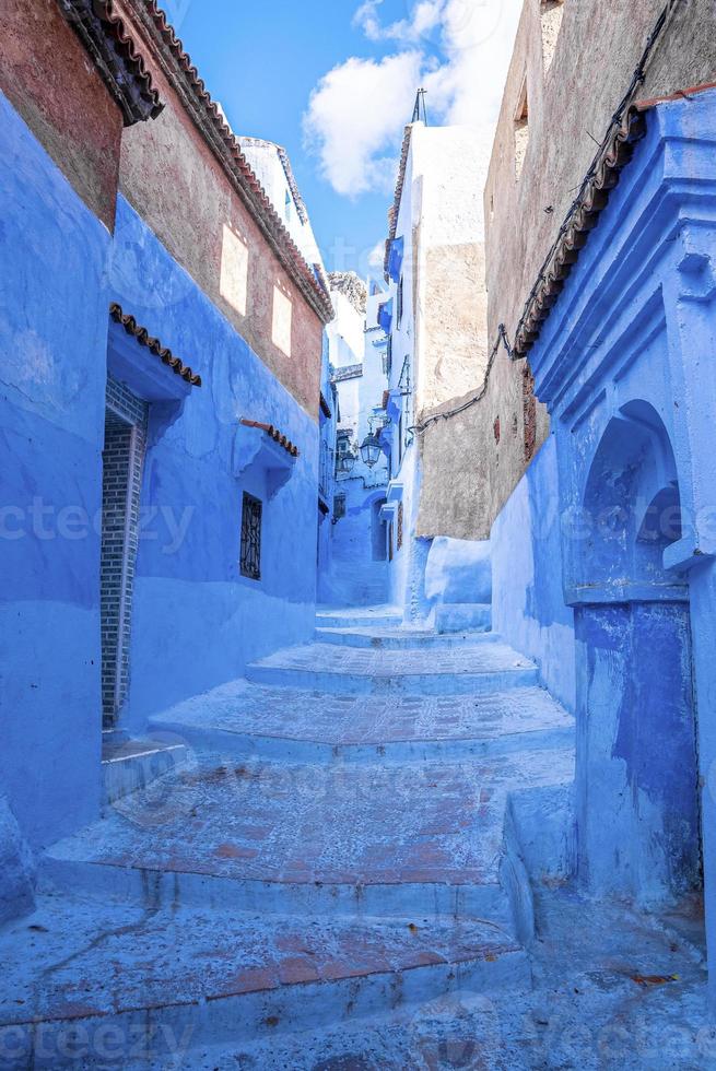 stretto vicolo della città blu con scalinata che porta a strutture residenziali su entrambi i lati foto