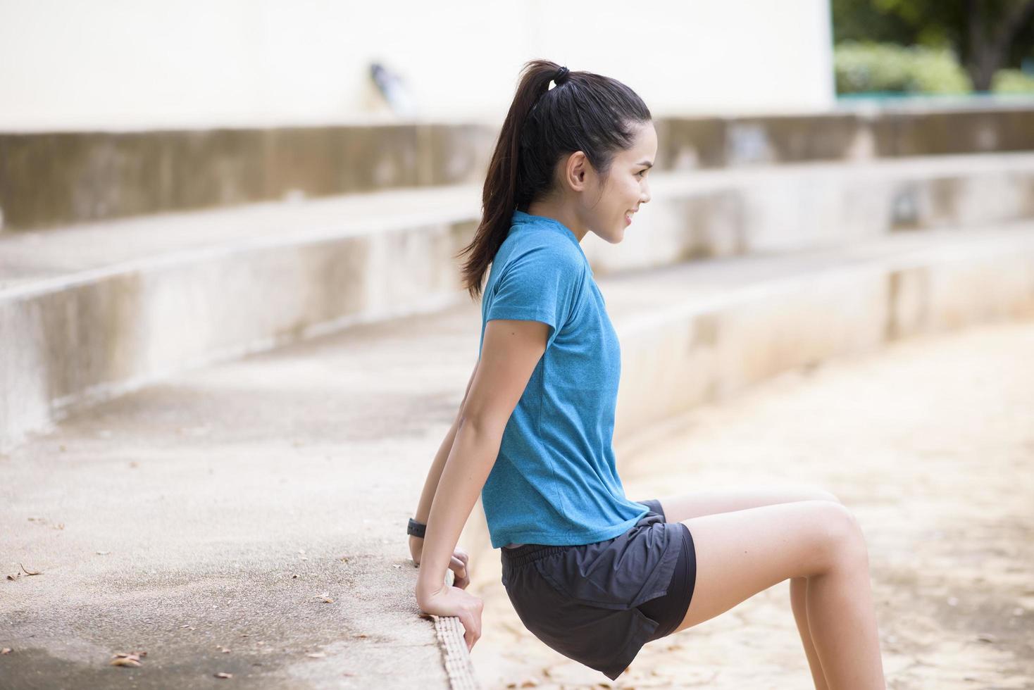 una giovane donna felice in abiti sportivi si sta esercitando nel parco foto