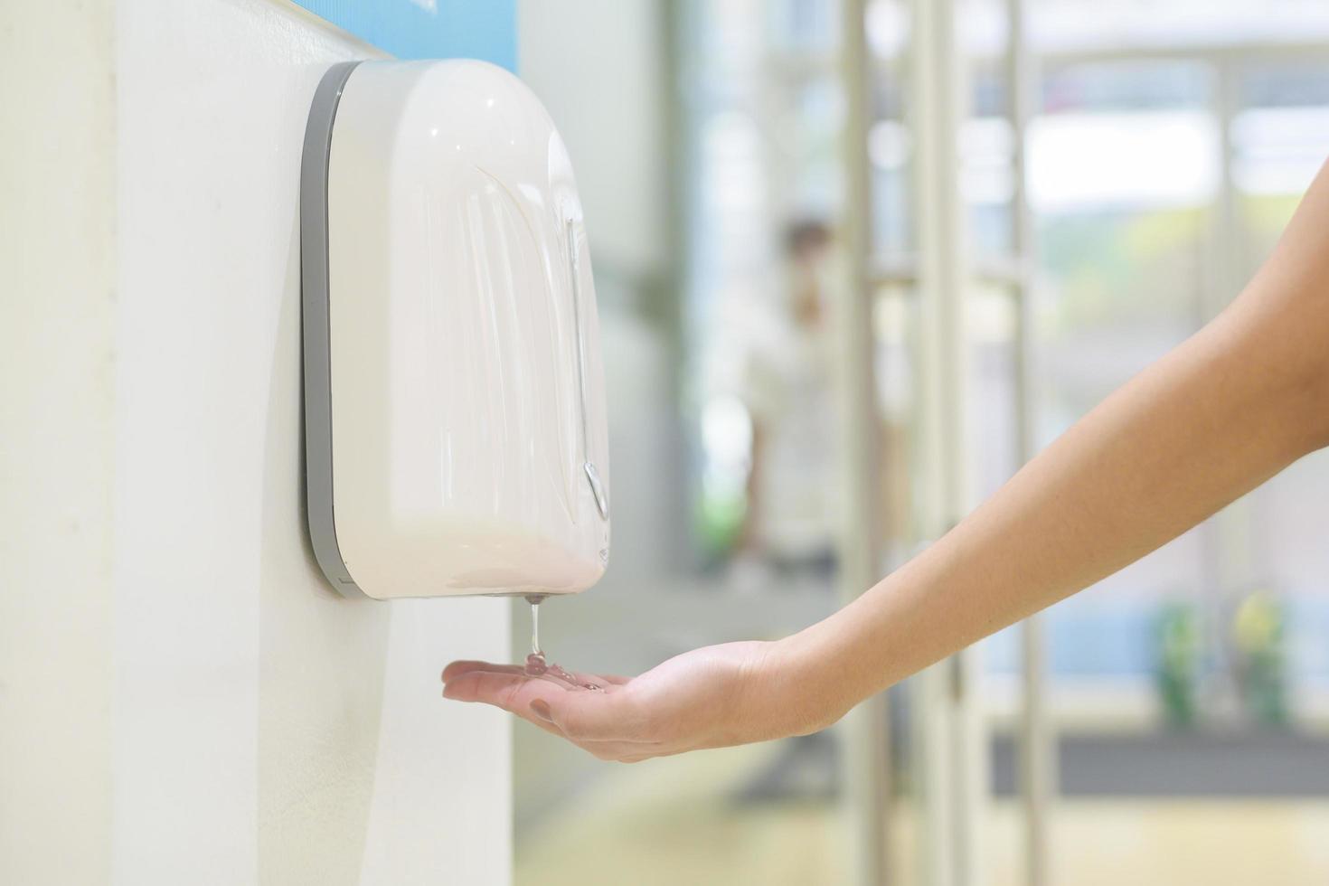 primo piano la mano della donna sta usando il gel alcolico nel centro commerciale, concetto di protezione covid-19 foto