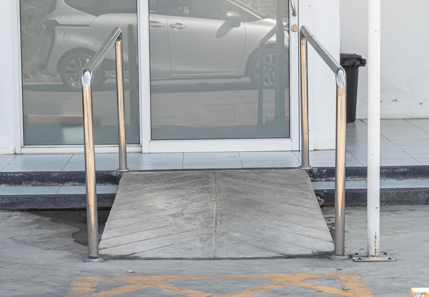 sentiero d'ingresso dell'edificio con rampa per anziani o disabili portatori di handicap su sedia a rotelle. foto