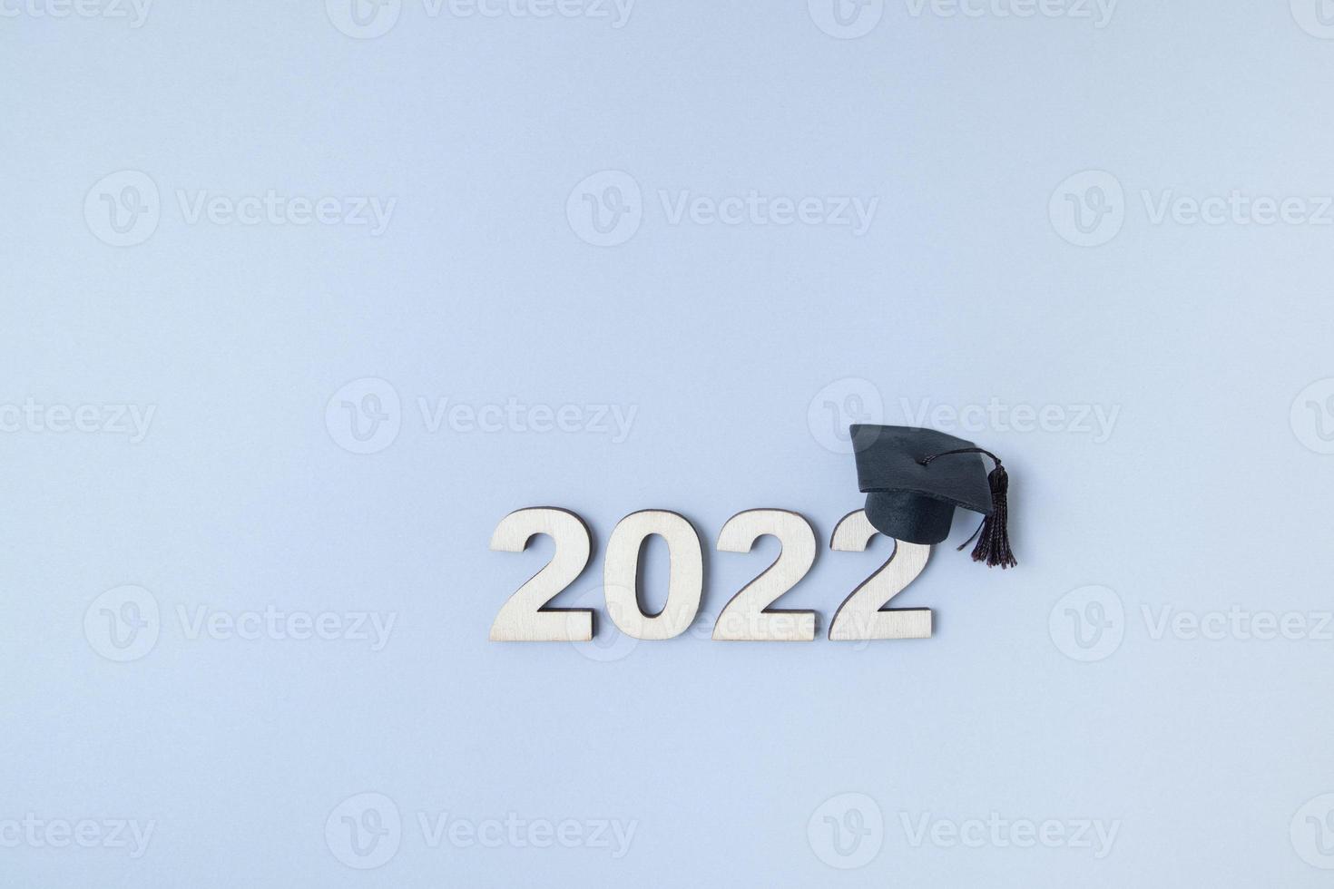 laurea 2022 con cappello laureato su numero di legno 2022 su sfondo grigio con spazio per la copia foto