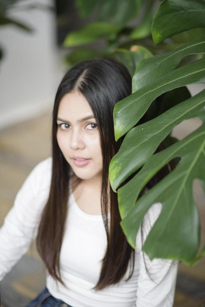 una giovane donna in abito bianco ritratto con piante verdi foto