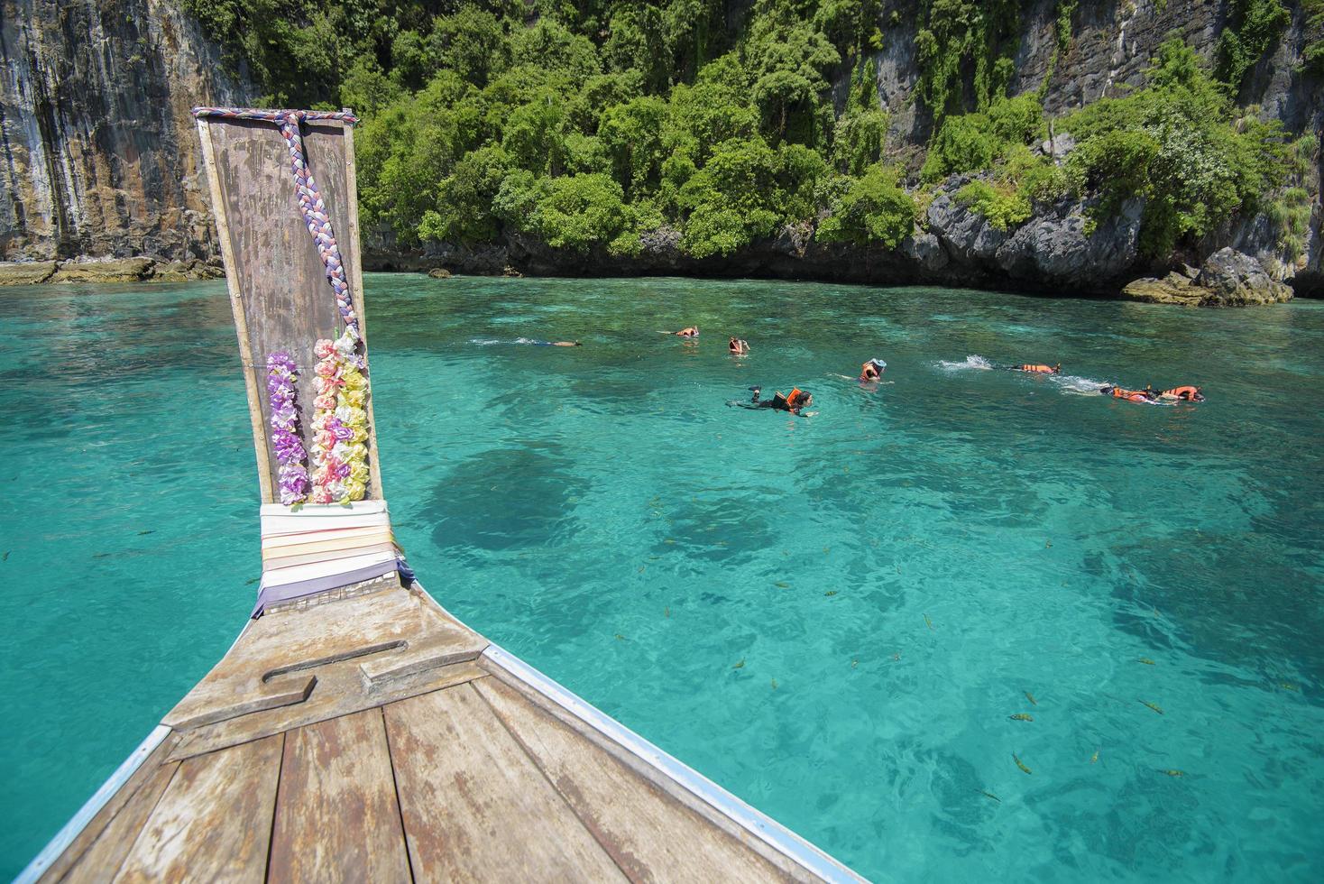 vista dalla tradizionale barca a coda lunga tailandese mentre i turisti fanno snorkeling e immersioni nell'oceano, isole phi phi, tailandia foto