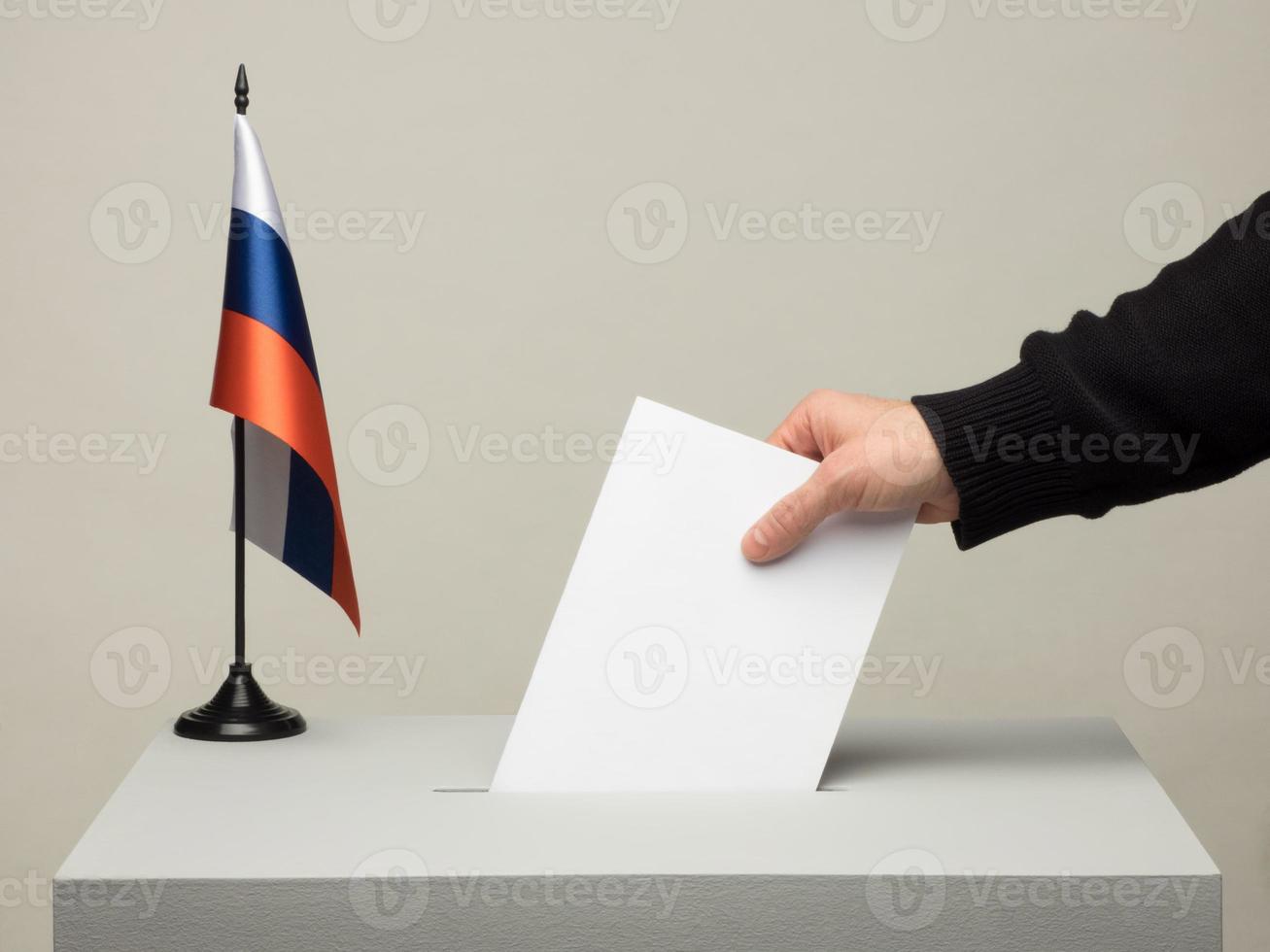 urne con bandiera nazionale della russia. Elezioni presidenziali. mano che lancia una scheda foto