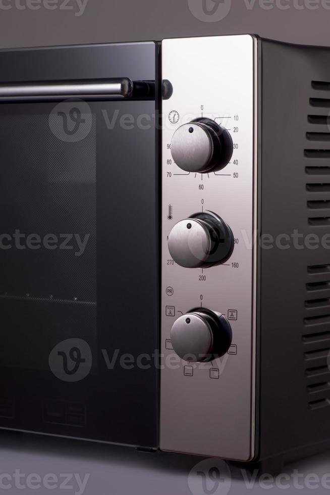termostato e maniglie su un moderno microonde. utensili da cucina foto