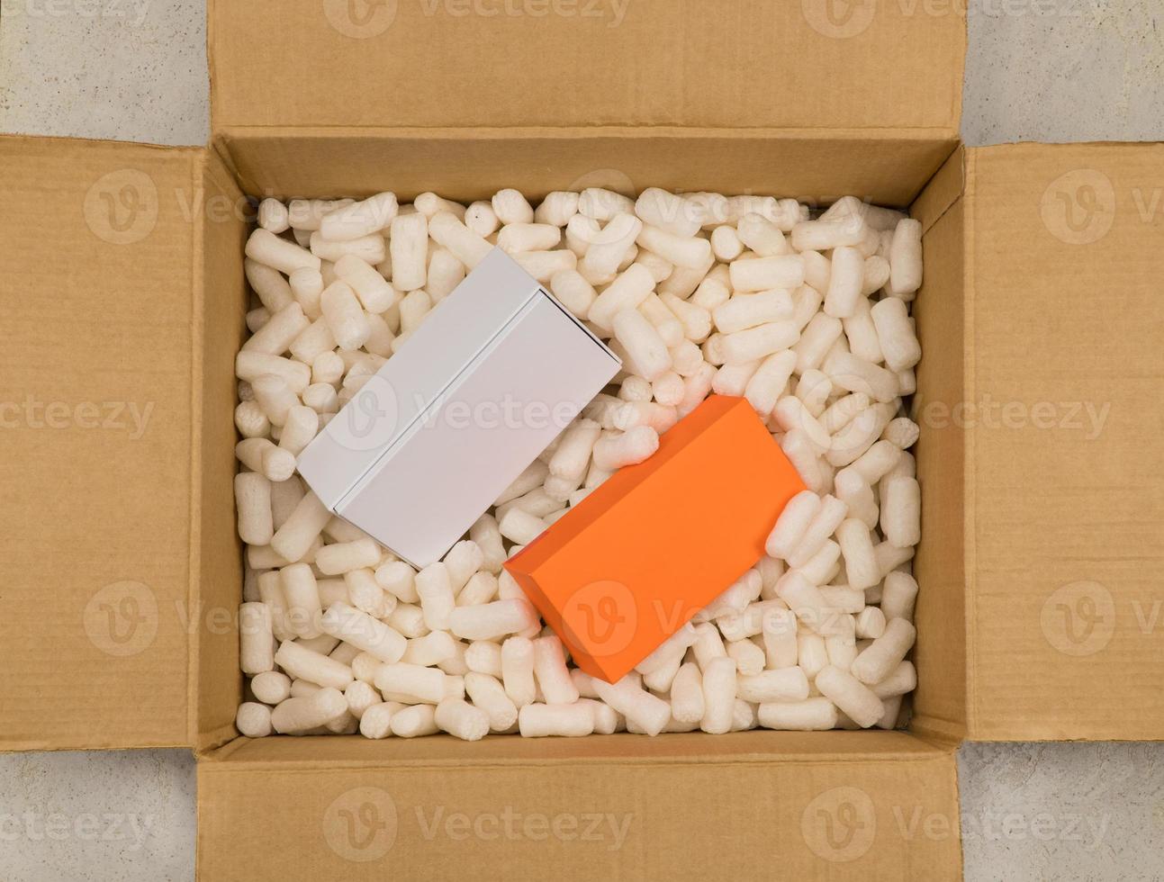 scatola di cartone con riempimento in polistirolo per un imballaggio sicuro. pacchetto regalo. vista dall'alto foto