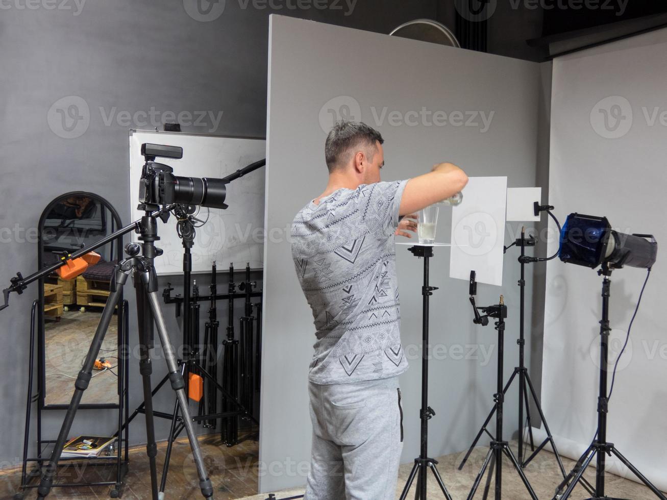 un giovane fotografo è preparato per la fotografia in studio. fotografia non intenzionale foto