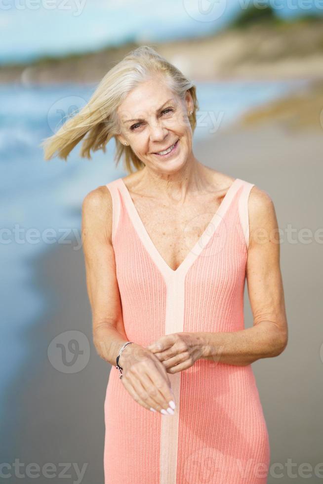 donna anziana che si gode la pensione in un rifugio sul mare. donna anziana sulla riva di una spiaggia. foto