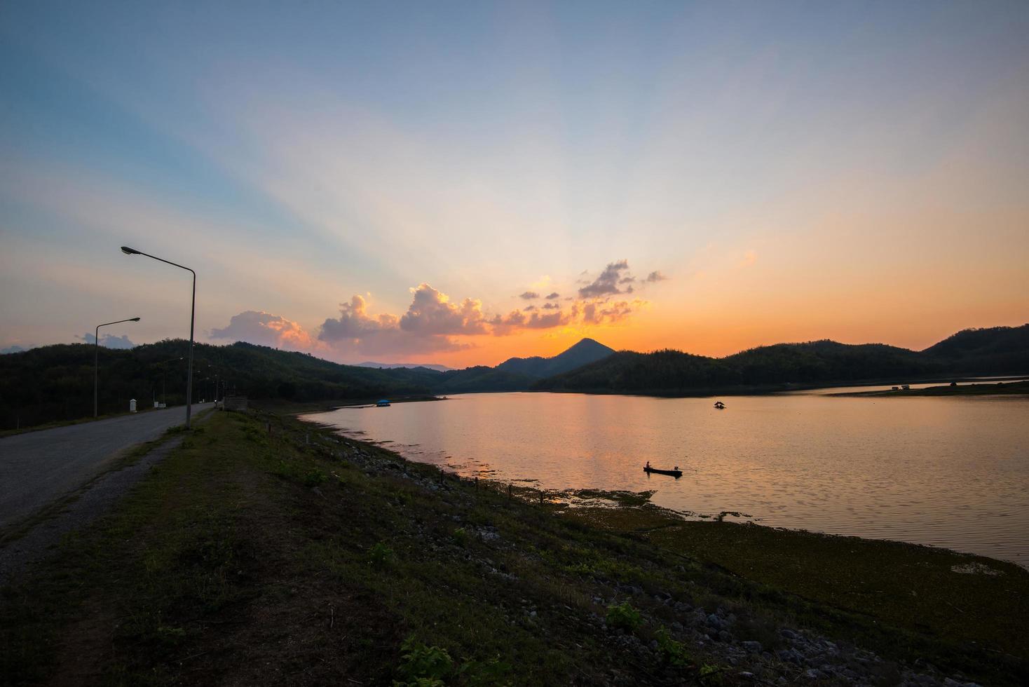 crepuscolo cielo fiume tramonto blu e arancione colore paesaggio lago sera tempo nuvole e silhouette montagne foto