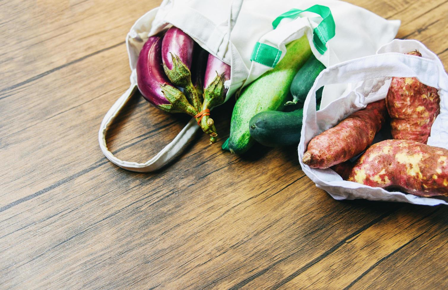 zero rifiuti utilizzare meno plastica concetto di verdure fresche organiche in sacchetti di tessuto di cotone ecologico su tavola di legno foto