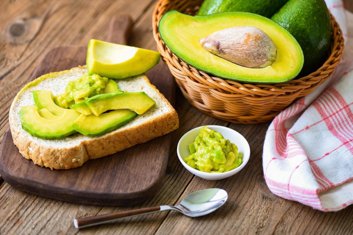fette di avocado e toast di avocado su fondo di legno frutta concetto di cibo sano - salsa di avocado purè foto