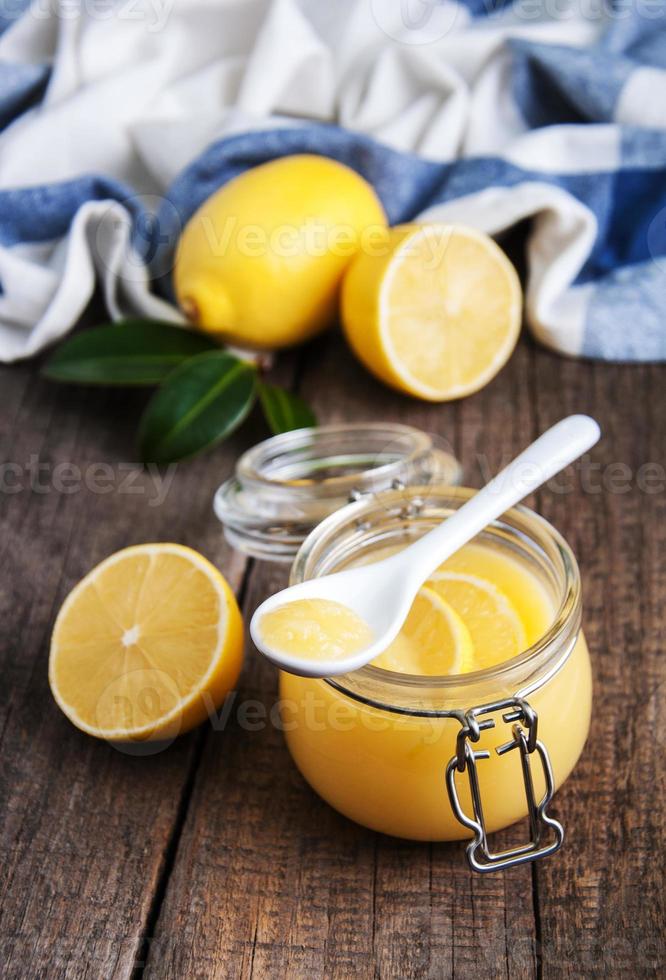 lemon curd in vasetto di vetro con limoni freschi foto