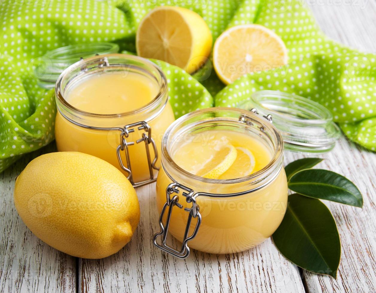lemon curd in vasetto di vetro con limoni freschi foto