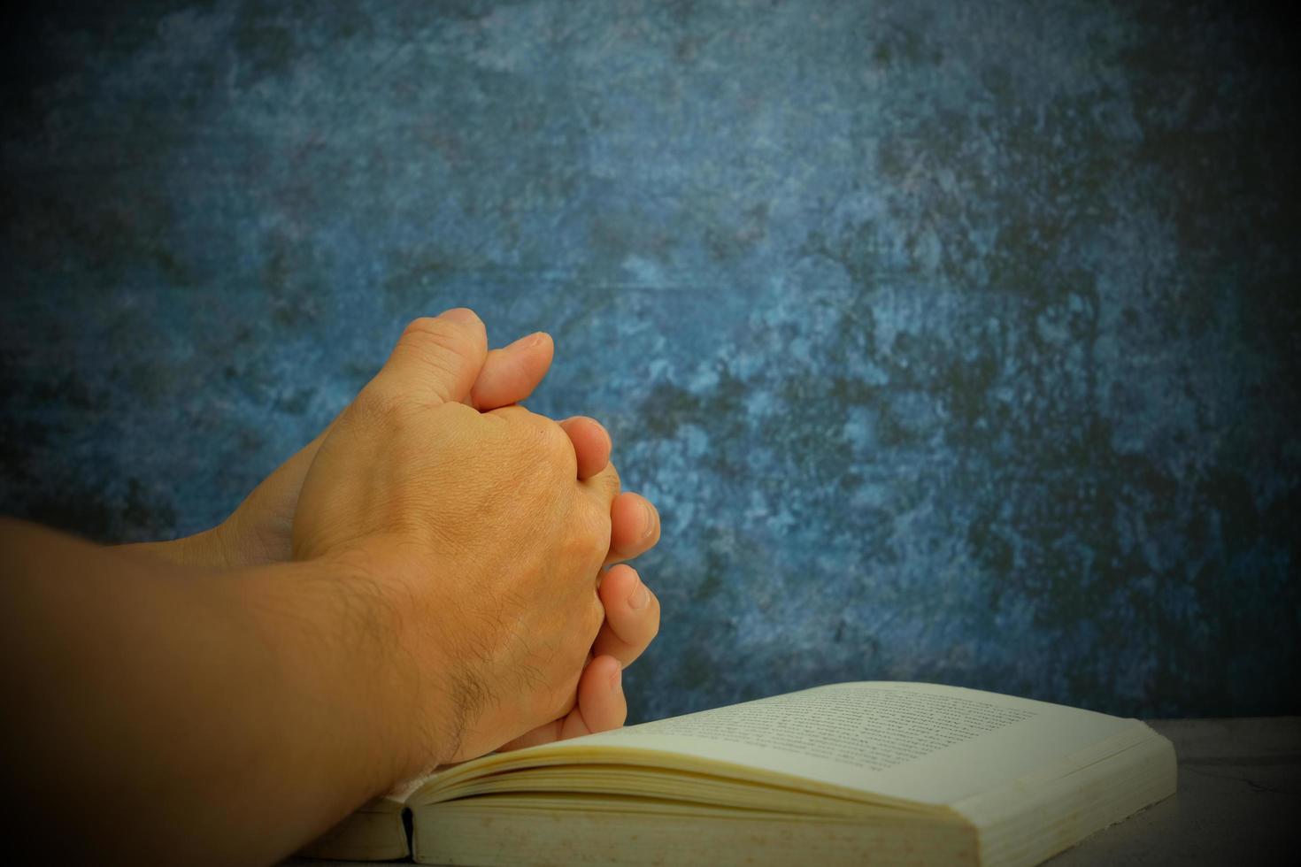 mani giunte in preghiera su una Sacra Bibbia in un concetto di chiesa per fede, spiritualità e religione, con una donna che prega sulla Sacra Bibbia al mattino. donna che prega con la Bibbia in mano foto