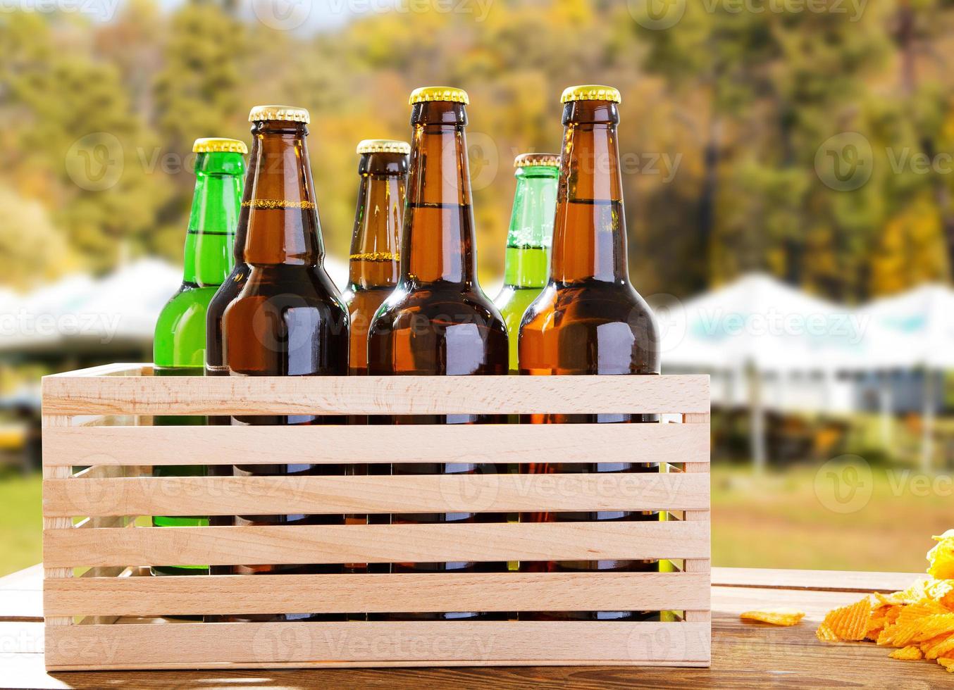 birra artigianale in scatola di legno su sfondo sfocato della zona dei pub estivi foto