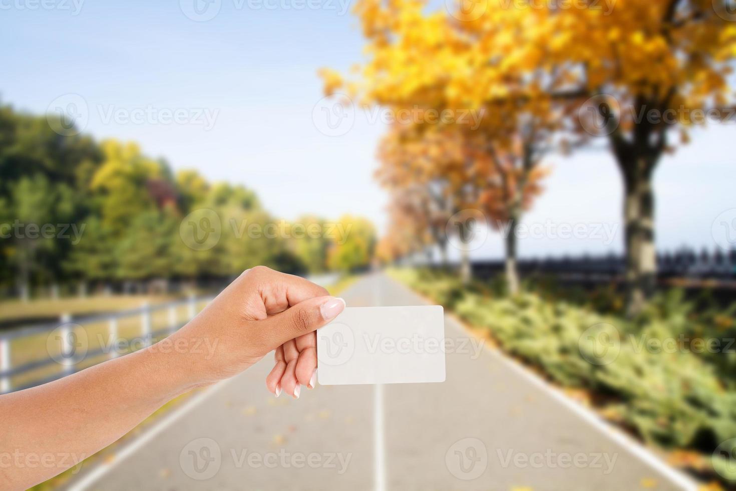 biglietto da visita della stretta della mano nera su strada asfaltata dello sfondo sfocato all'orizzonte nel parco foto