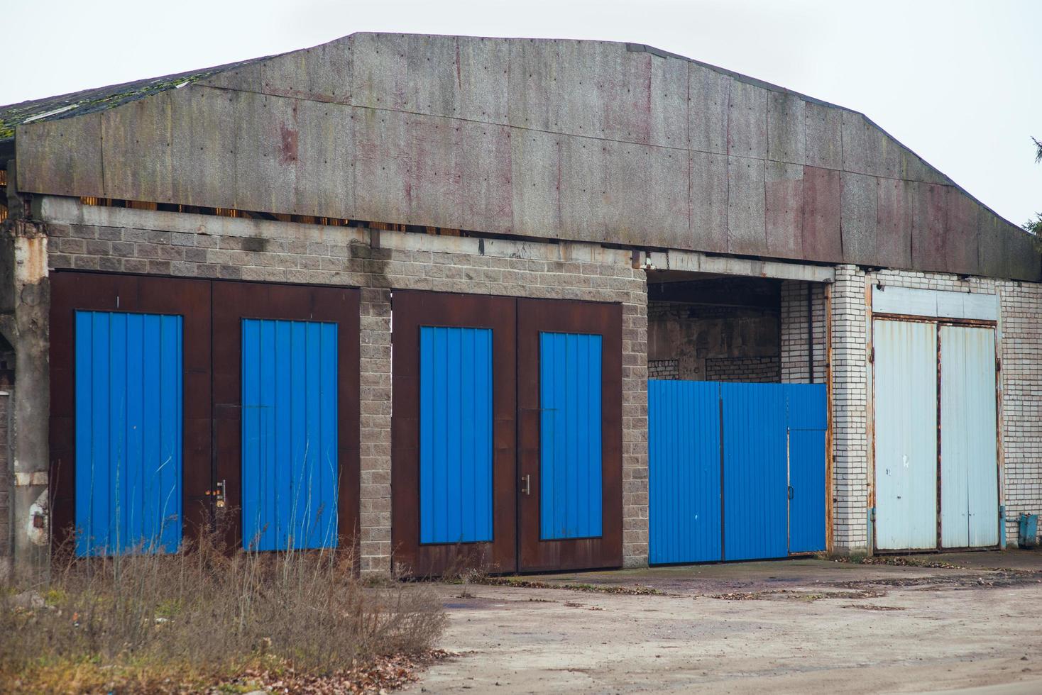 vecchio magazzino, capannone industriale, exerier. vecchi cancelli di metallo per l'ingresso delle auto foto