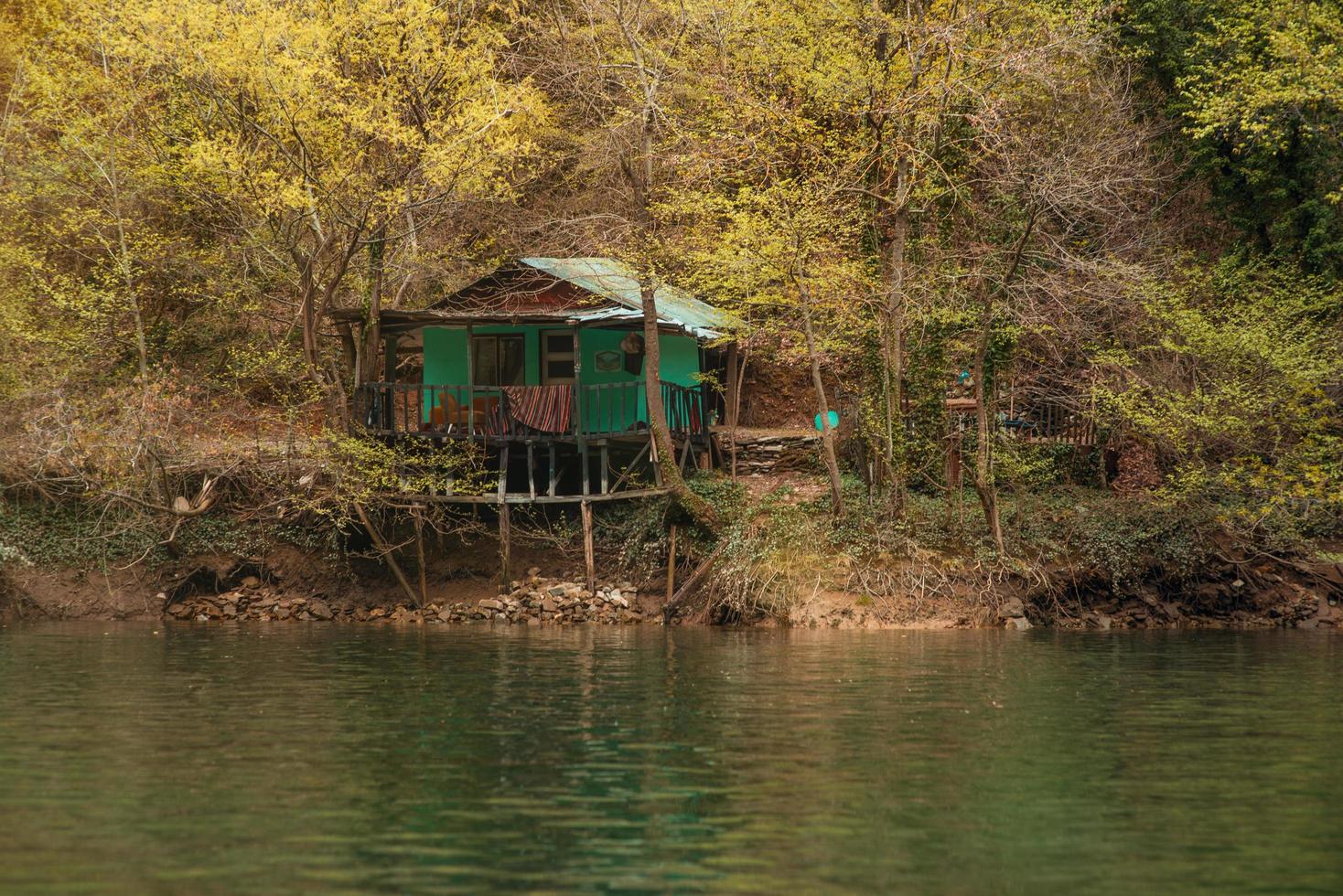 un'antica baita sulle rive di un fiume di montagna, tra la gola. foto