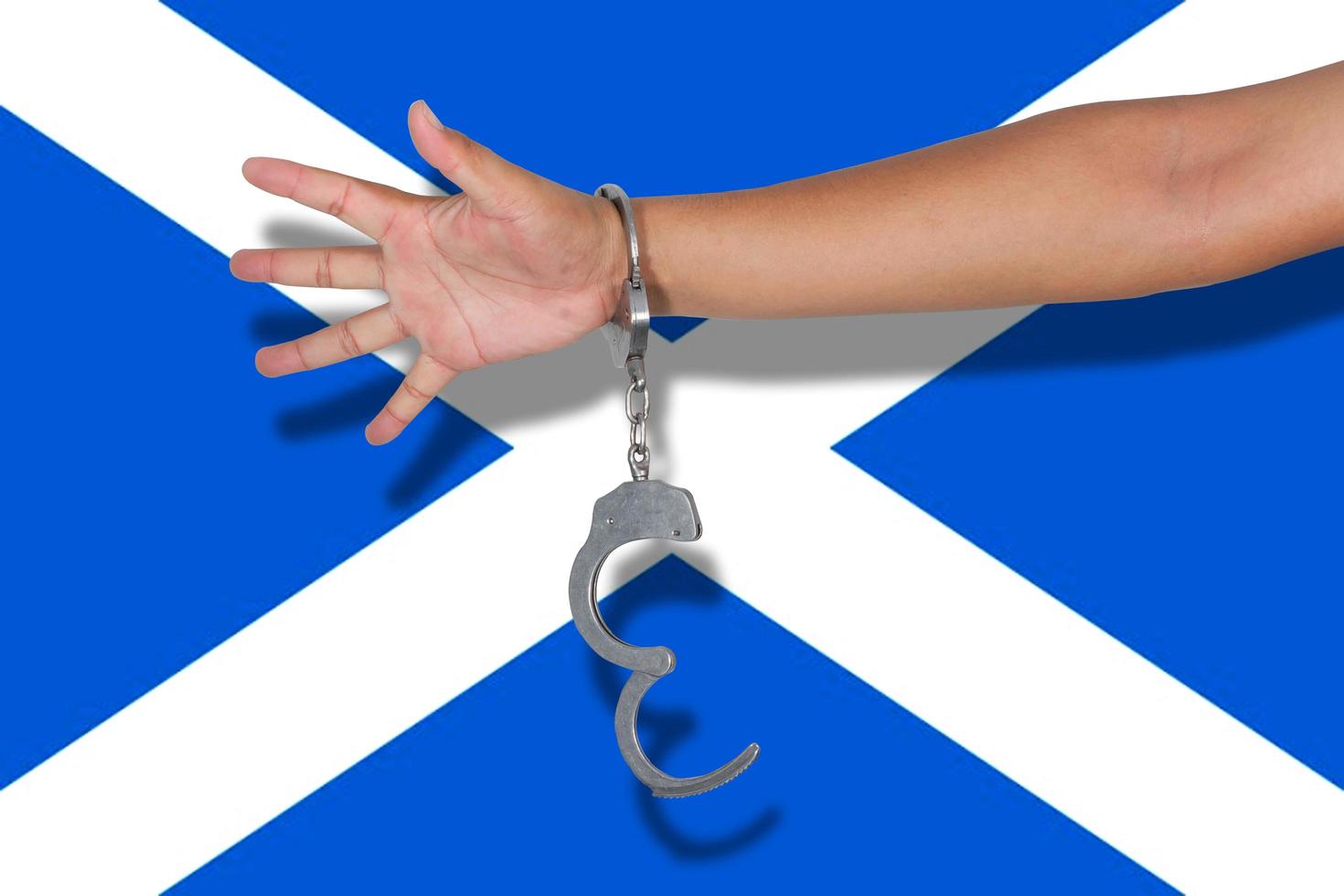 manette con la mano sulla bandiera della Scozia foto