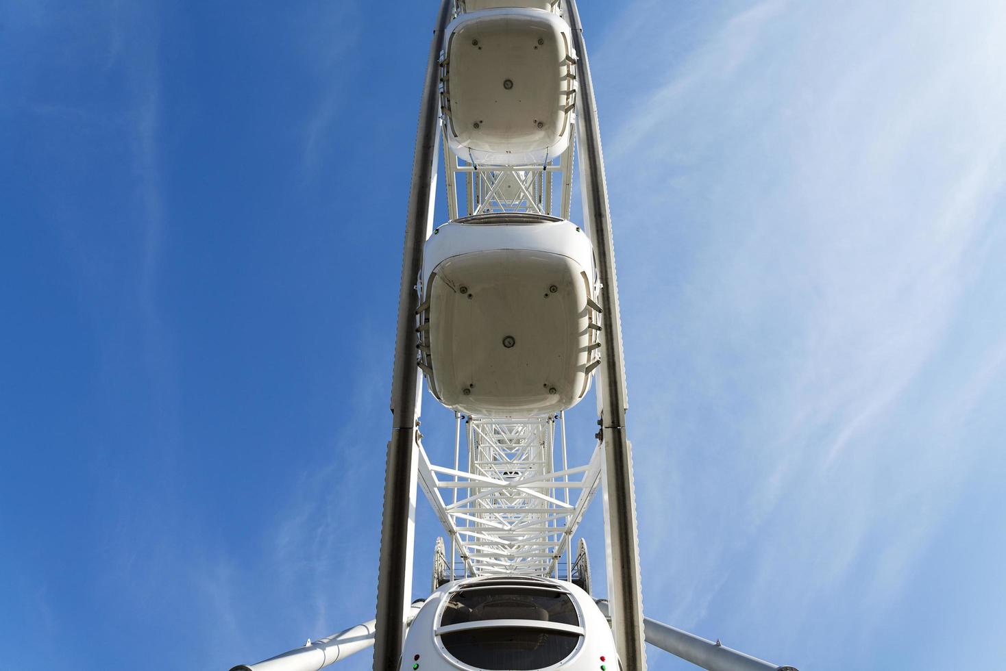 grande ruota panoramica su sfondo azzurro del cielo, primo piano foto