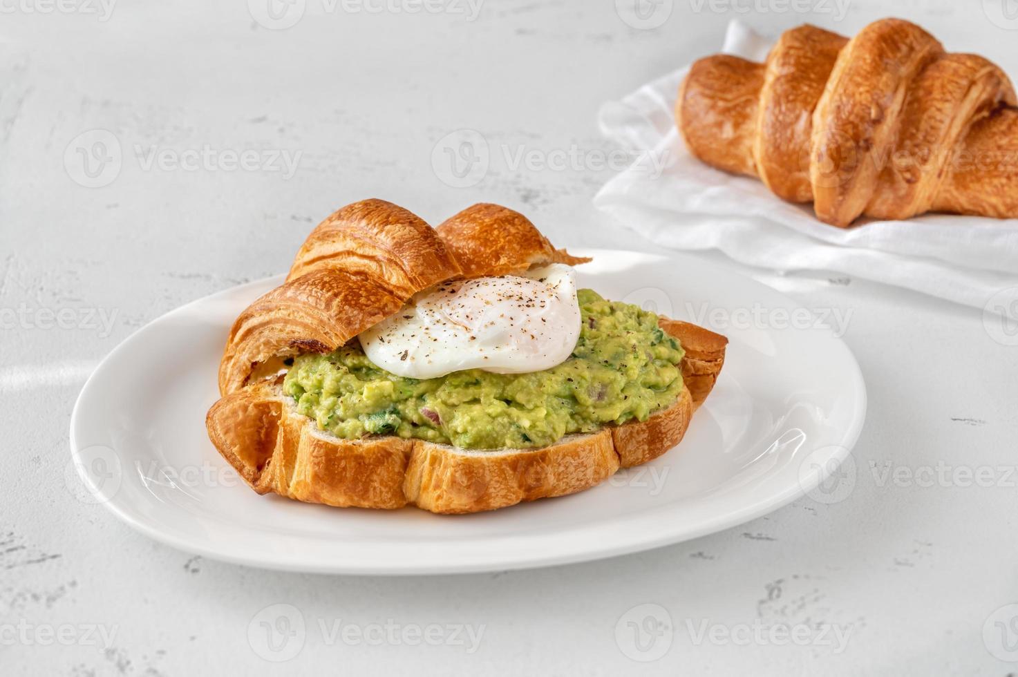 croissant con guacamole e uovo in camicia foto