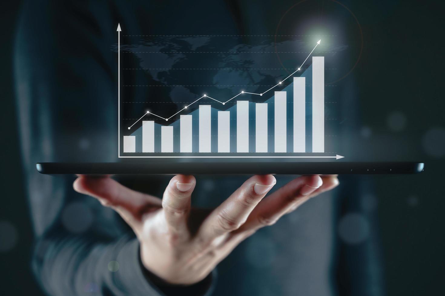 uomo d'affari che utilizza una tavoletta digitale con un grafico aziendale che appare su uno schermo virtuale. crescita aziendale e strategia, concetto di indicatore del mercato azionario. foto