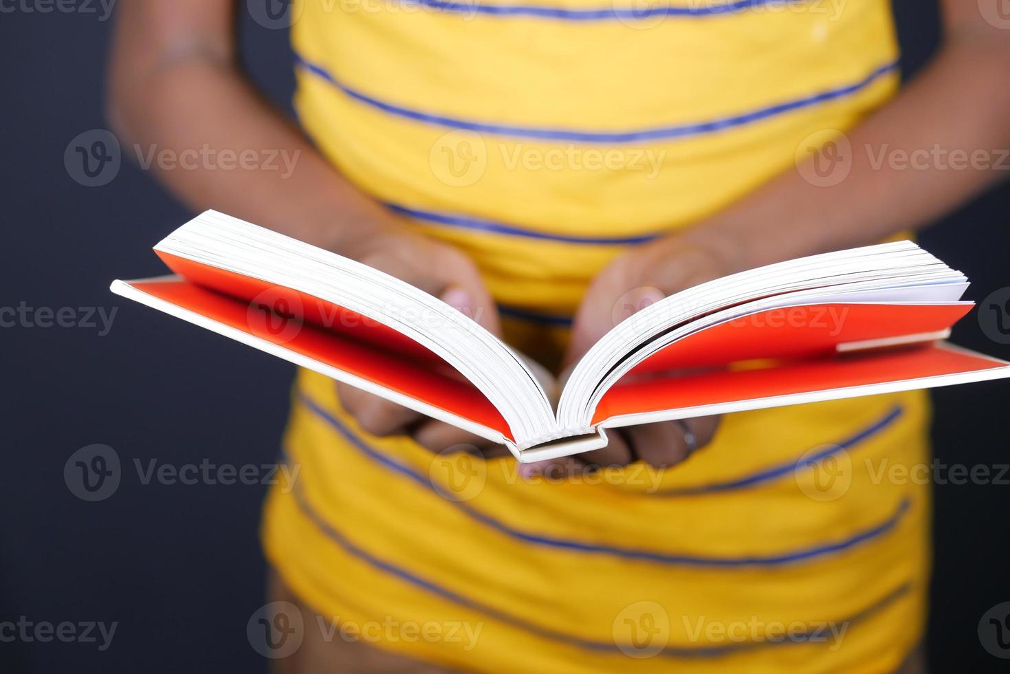 primo piano della mano del giovane che legge un libro foto