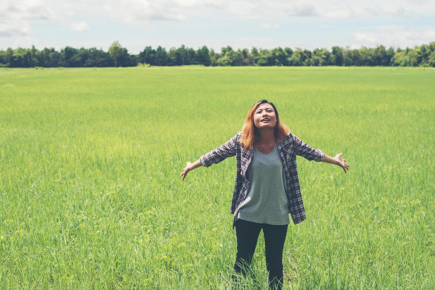 libertà giovane bella donna che allunga le braccia verso il cielo godere e felice con l'aria fresca al pascolo. foto